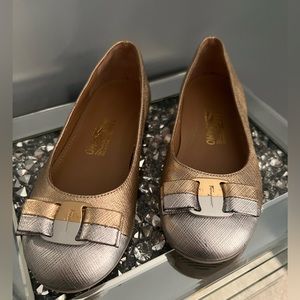 Girls Salvatore Ferragamo gold and silver shoes with bows.